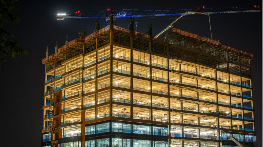 Modern residential home under construction in 2026 with construction workers, building materials, and real estate investment planning.