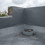 Waterproofed terrace corner with coving at the parapet joint and a rainwater outlet (illustrative image)